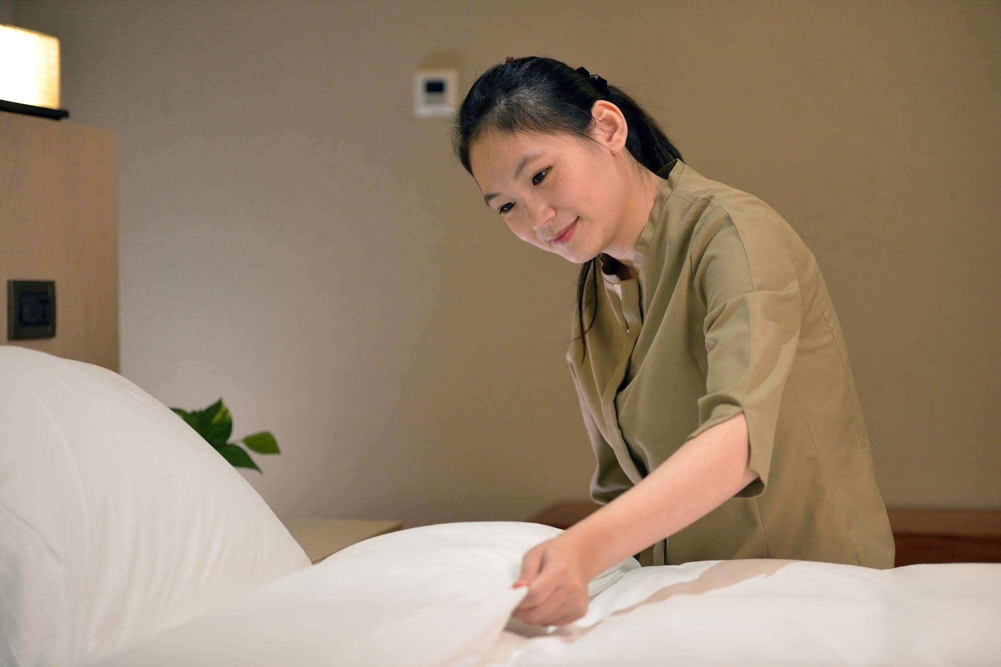 Chihpen Century Hotel Wenquan Exteriör bild A chambermaid making a bed
